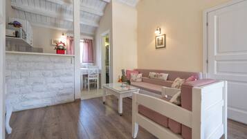 Una sala acogedora con un sofá blanco, una mesa de centro y un mueble blanco decorado con objetos.