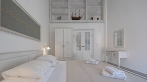 A hotel room with a large bed, a wardrobe, a mirror, and a ship model on the wall. - Marinero Apartments (Budva)