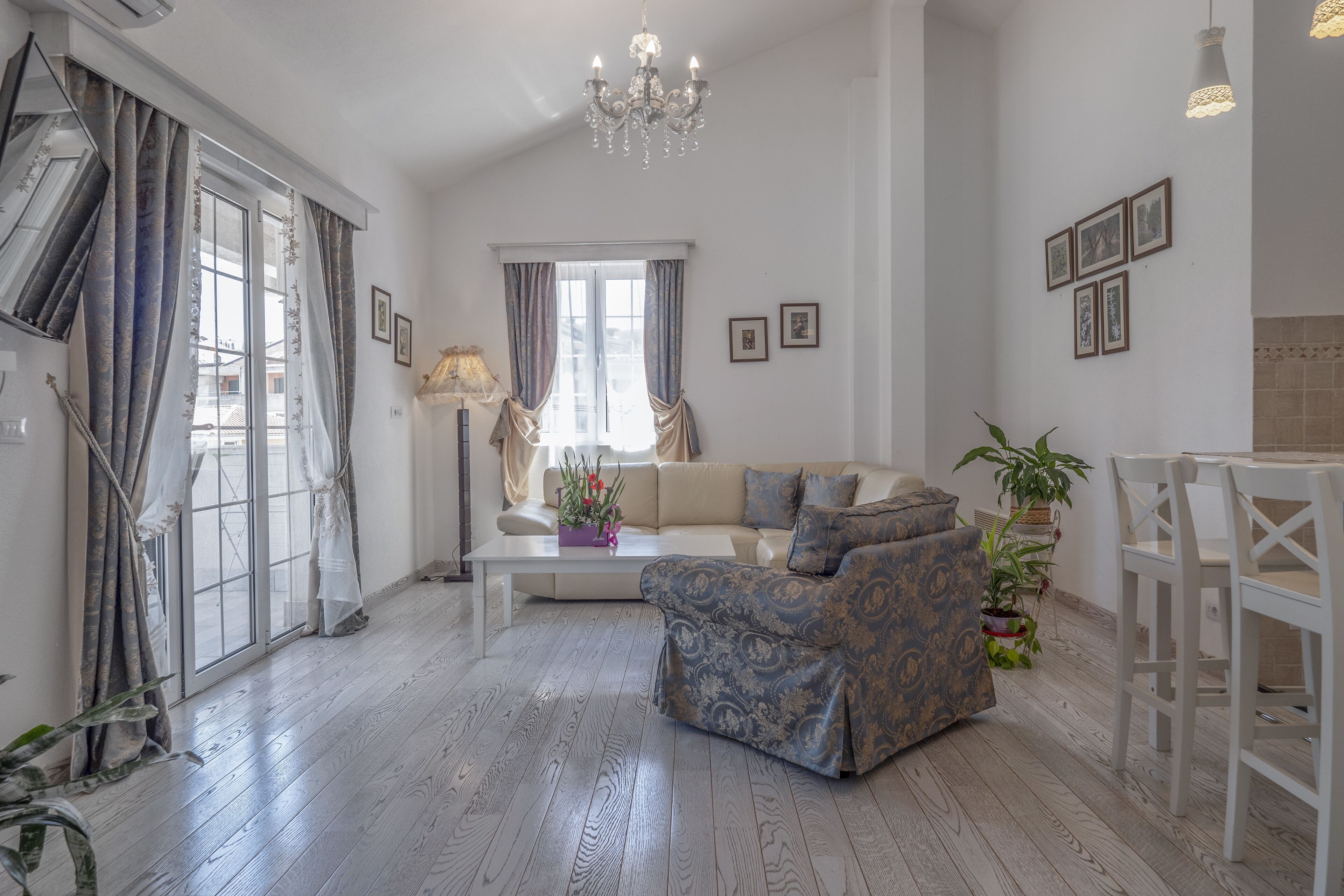 Un saló espaiós amb un sofà, una taula de centre i una zona de menjador amb una cadira.