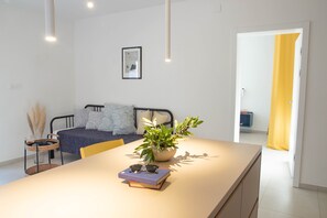 Una sala moderna con un sofá, una mesita de centro y una planta en maceta.