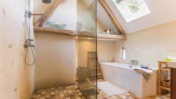 Grand tweepersoonskamer (La Magny) | Badkamer | Een haardroger, handdoeken, zeep, shampoo
