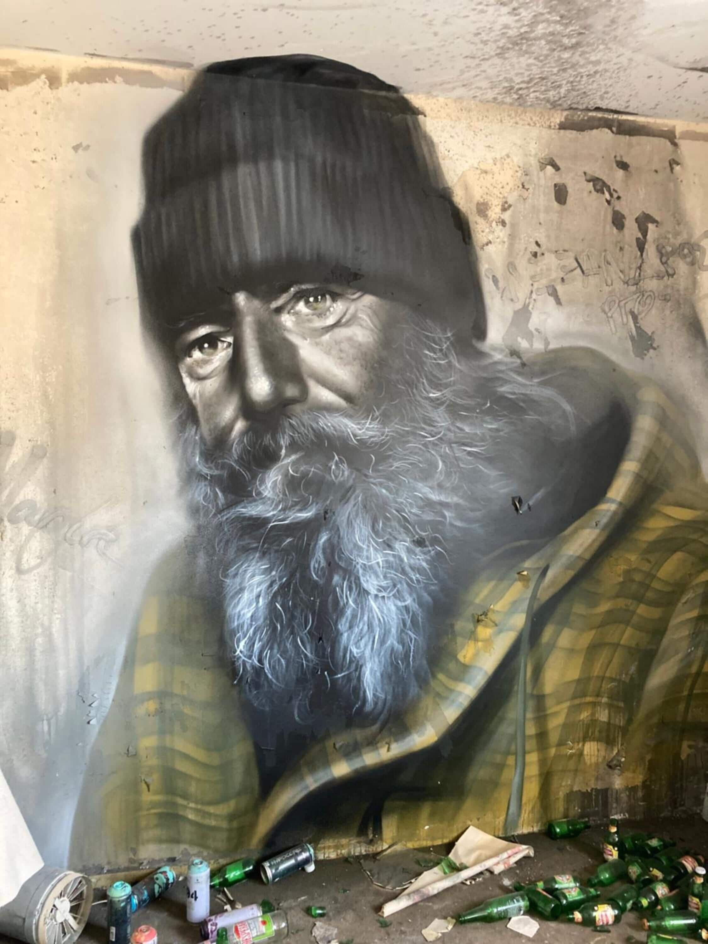 Une fresque représentant un homme barbu portant une chemise à carreaux.