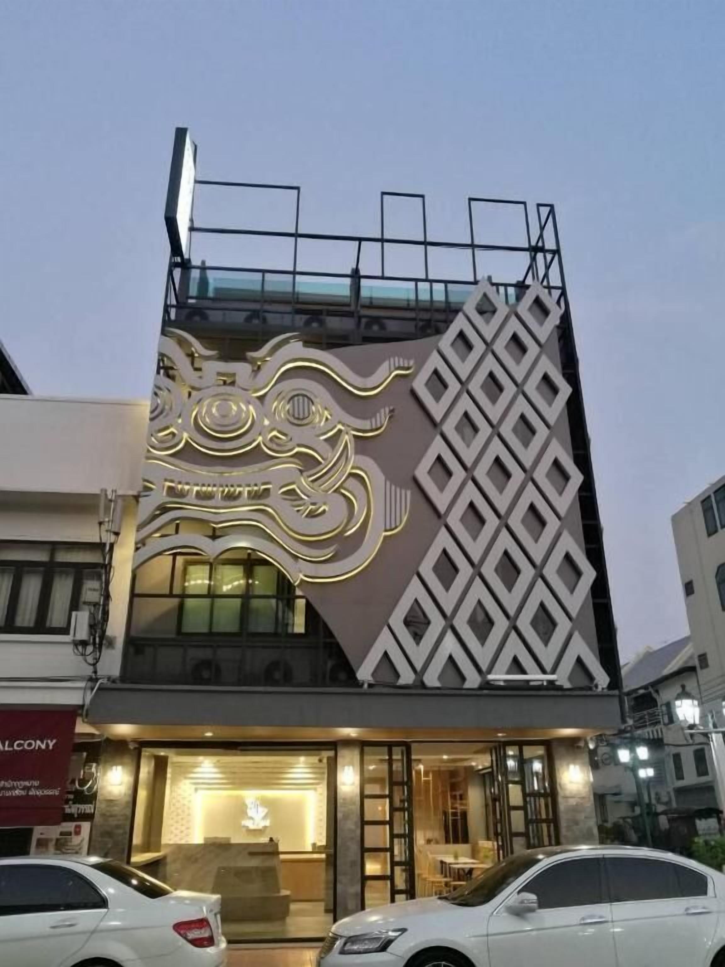 A modern building with a unique facade featuring geometric patterns and a large illuminated design.