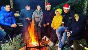 En gruppe mennesker samlet omkring et lejrbål udendørs.