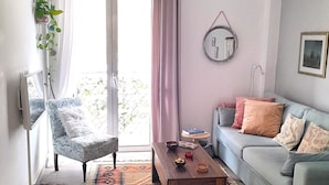 Ein Wohnzimmer mit Sofa, Sessel, Couchtisch und einem gemusterten Teppich.
