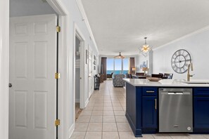 A modern kitchen with a built-in dishwasher, a large island, and a view to the outside.