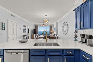 A modern kitchen with a central island, a built-in dishwasher, and a dining area with a view.
