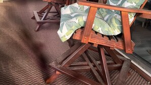 A porch with wooden rocking chairs, a small table, and a ceiling fan. - Beach Vacation Condo (Myrtle Beach)