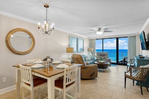 Relax in this stylish living area with a dining table for four, comfortable seating, and a large window offering ocean views.