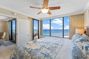 A bedroom with a bed, a ceiling fan, a view of the ocean, and a door leading to a balcony. - Elevated Gulf-Front Comfort Overlooking the Dunes (Panama City Beach)