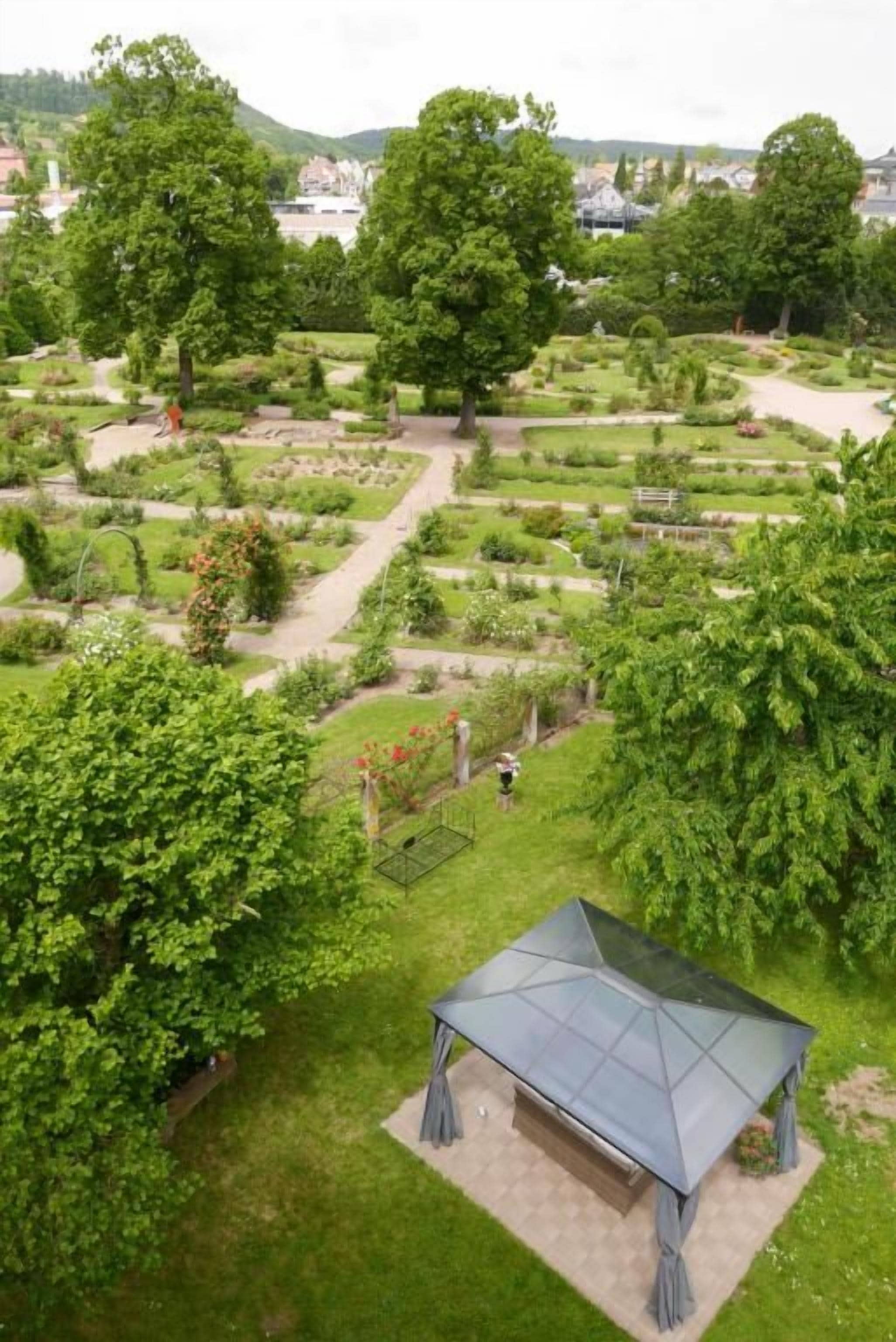A garden with a gazebo, pathways, and various plants.
