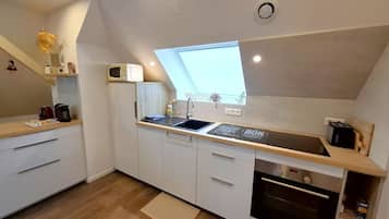 A compact kitchen with a built-in microwave, a sink, and a toaster.