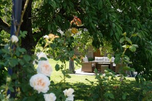 A garden with a seating area and a pergola. - Le Jardin des Roses (Saverne)