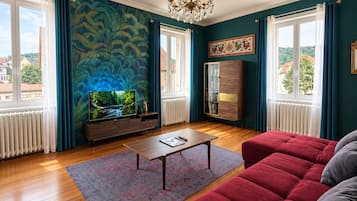 Un salon comprenant un téléviseur, un canapé, une table basse et un mur décoratif.