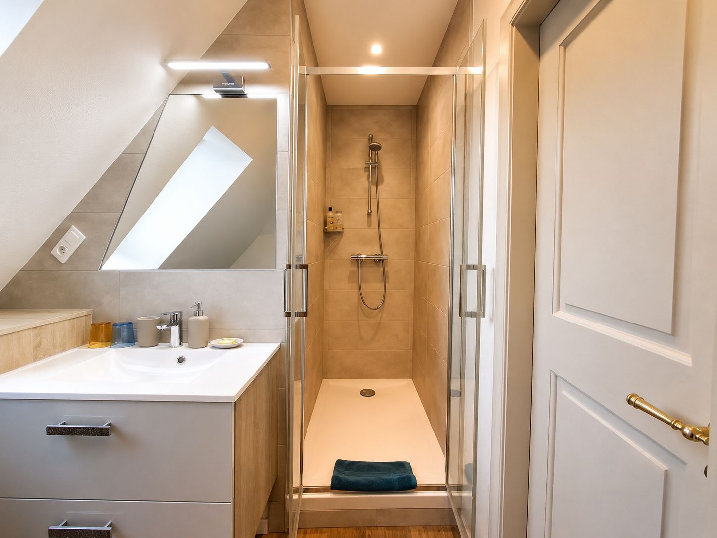 A modern bathroom with a shower, a sink, and a mirror.