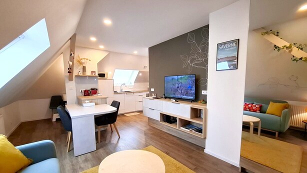 Un appartamento moderno con cucina, zona pranzo e soggiorno.