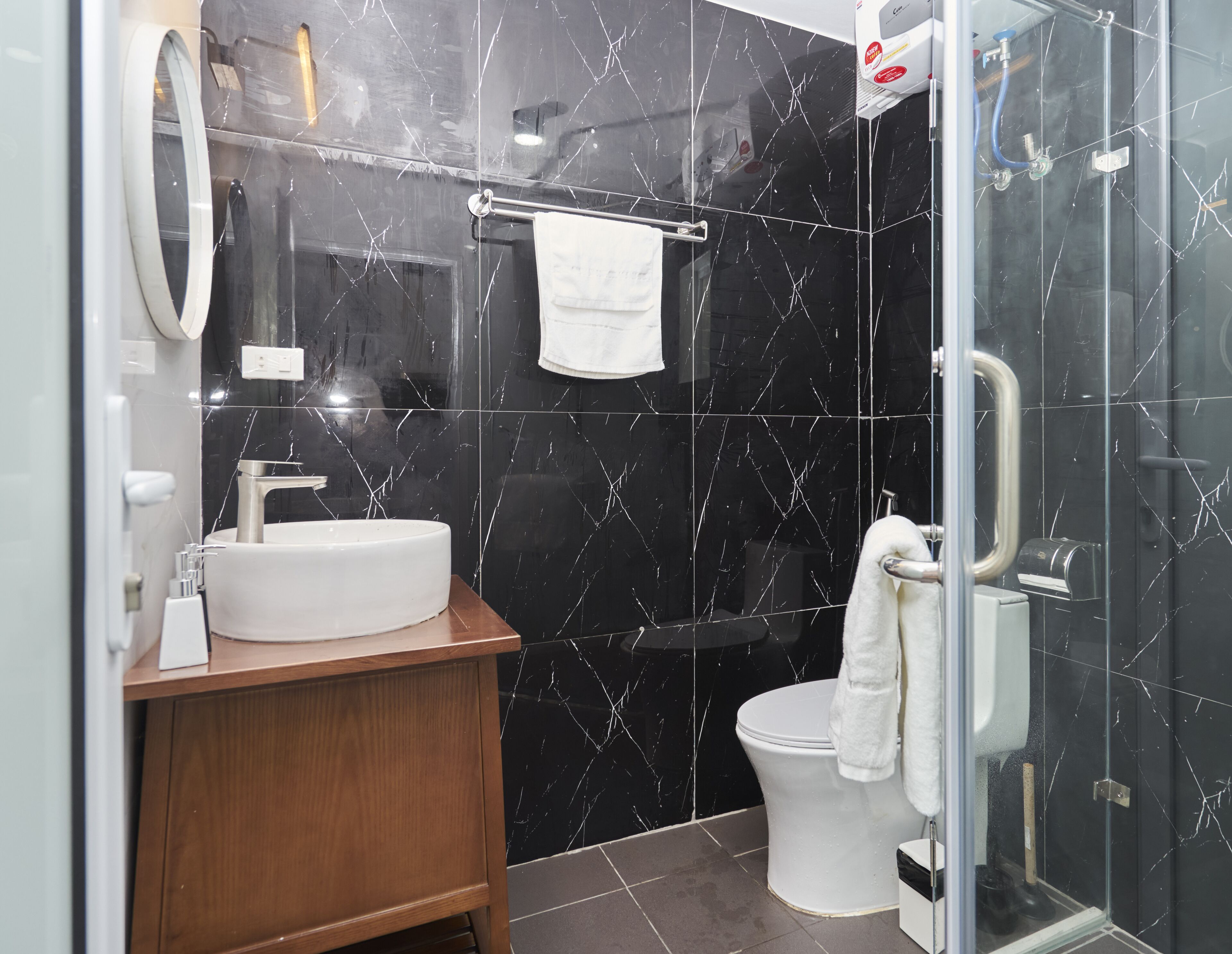 A modern bathroom with a white sink, mirror, and toilet.