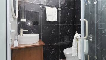 A modern bathroom with a white sink, mirror, and toilet.