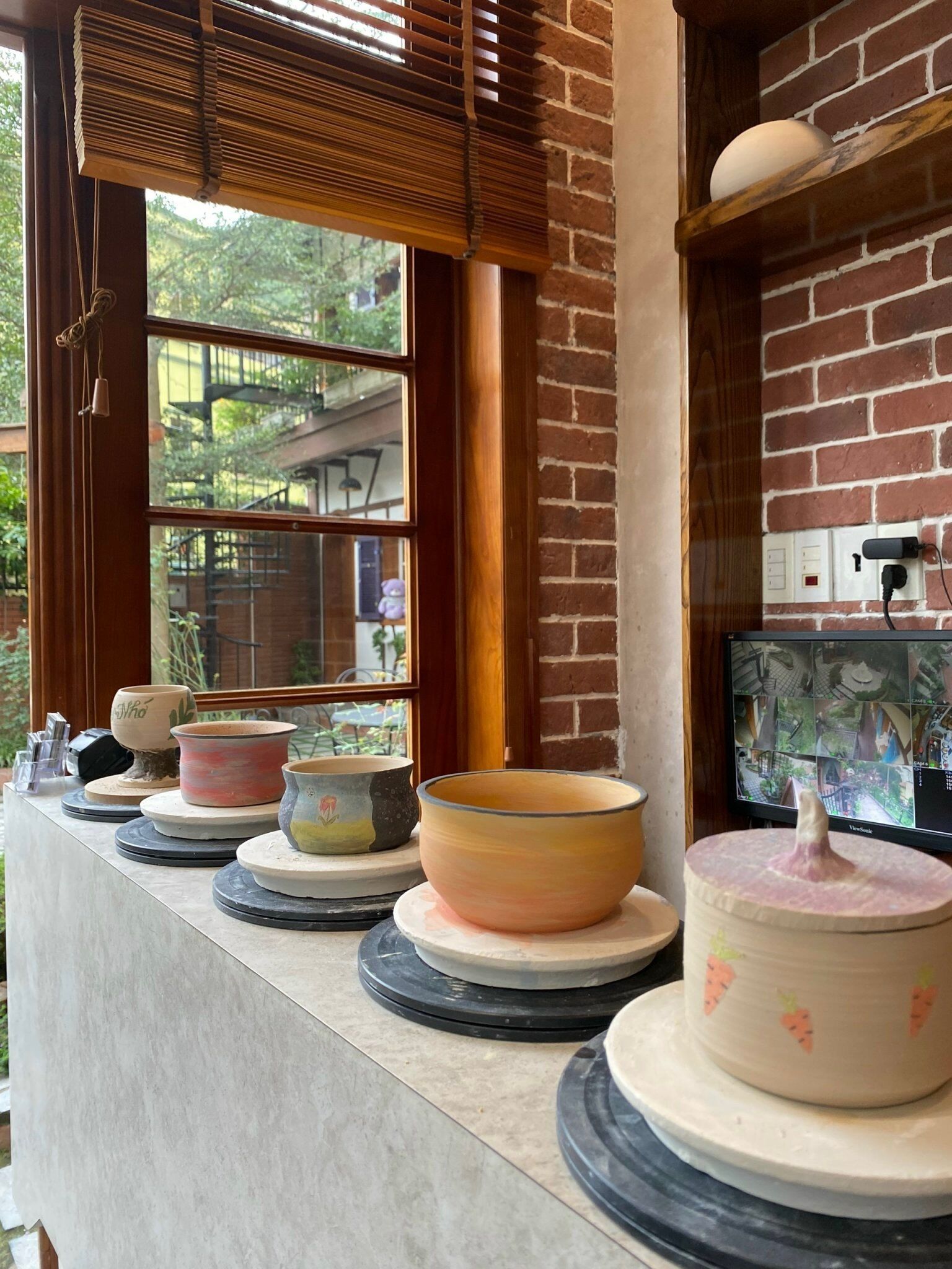 A kitchen counter with various ceramic bowls and a decorative item on a rotating stand.