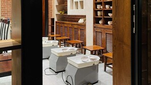 Ein modernes Interieur mit Ziegelwänden, Holzmöbeln und einer zentralen weißen Säule.