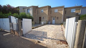 A residential street with houses, a paved driveway, and a white gate. - House in Grau d'Agde, 300 meters from the sea (Agde)