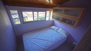 A bedroom with a bed, a window, and a built-in cabinet. - House in Grau d'Agde, 300 meters from the sea (Agde)