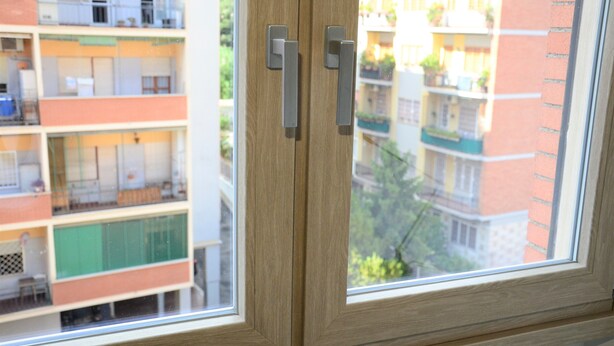 A window with a view of multi-story buildings, including balconies and windows. - Egle's House (Roma)