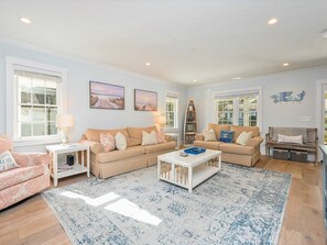 Relax in this serene living room with a beige sofa, coffee table, and patterned rug.
