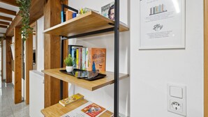 Una estantería con libros, una planta en maceta y un letrero enmarcado.