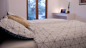 Ein Schlafzimmer mit Bett, Schreibtisch und Fenster.