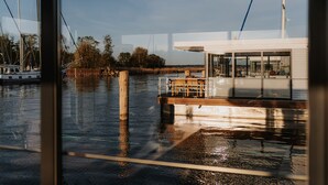 En båt låg förtöjd vid en småbåtshamn, med ett trädäck och en hytt med glasväggar.