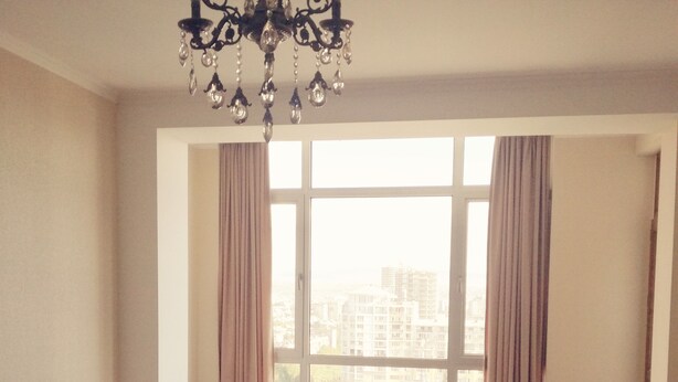 A living room with a sofa, a rug, and a large window with curtains. - Saburtalo flat - Comfort created for you! (Tbilsi)
