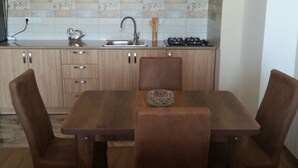 A modern kitchen with wooden cabinets, a stainless steel sink, and a gas stove. - Saburtalo flat - Comfort created for you! (Tbilsi)