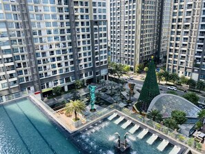 Enjoy the tranquil pool area surrounded by lush gardens and a water feature.