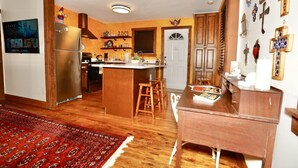A kitchen with wooden cabinets, a refrigerator, and a dining area with stools. - HistoricHotspot! walk to bars, resturaunts, shops. GREAT NIGHTLIFE! Pet Friendly (Jacksonville)