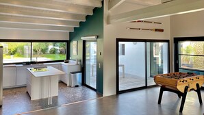 Un intérieur moderne comprenant un espace cuisine, une table à manger et une table de baby-foot.