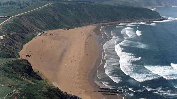 A coastal landscape with a sandy beach, a road curving along the coastline, and a view of the ocean. - VILLA LOUISE BILBAO, IN A GREEN SETTING, CLOSE TO THE CITY AND BEACHES (Berango)
