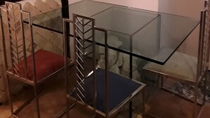 A dining area with a glass table and metal chairs, a wall-mounted sculpture, and patterned wall decor. - Vecchia Roma House apartment  (Roma)