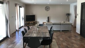 A spacious living area with a dining table, sofa, and TV. - Villa located in the heart of Provence with private pool on 3 hectares. (Roquevaire)