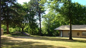 A house with a metal roof, surrounded by trees and a grassy yard. - Ft Gibson Lake OK near Sequoyah State Park (Hulbert)