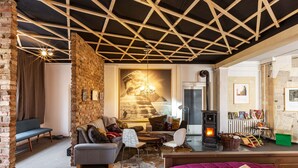 A cozy living room with a fireplace, a sofa, a coffee table, and a dining area. - Holiday Loft AUGUST’S TREASURE CHEST (Marienberg)