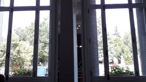 A room with large arched windows, a central column, and a view of the outdoors.