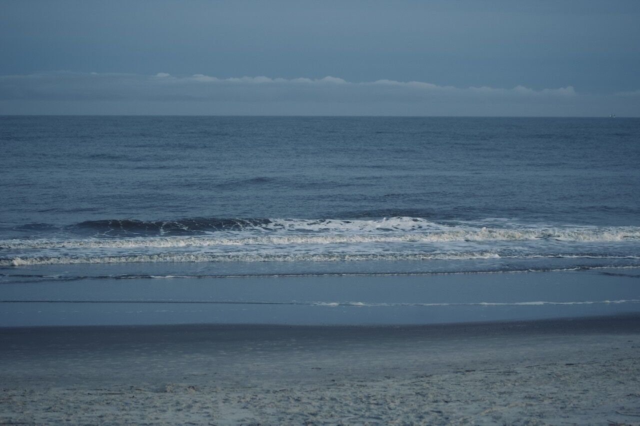 A beach with waves approaching the shore.