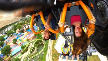 Blick von einer Achterbahn, inklusive der Gleise und des umliegenden Freizeitparkbereichs.