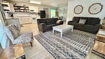 Ein Wohnzimmer mit einer Couch, einem Couchtisch und einem gemusterten Teppich.
