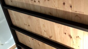 Pared de madera con vigas horizontales y nudos visibles.
