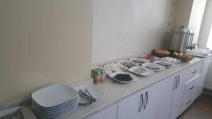 Montaje de un bufé de desayuno con diferentes alimentos y utensilios.
