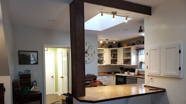 A kitchen with white cabinets, a granite countertop, and a ceiling light fixture.