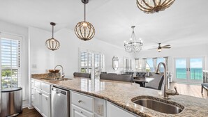 A spacious kitchen with granite countertops, stainless steel appliances, and pendant lighting. - Grand Playa 301, Scenic 30A, Gulf Front Condo, Pool with Private Beach Access (Seagrove Beach)