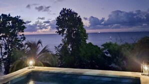 Una piscina con vista al océano y un cielo nublado.